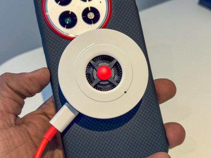 Le chargeur Airvooc OnePlus 50W attaché à un OnePlus 13 dans la main