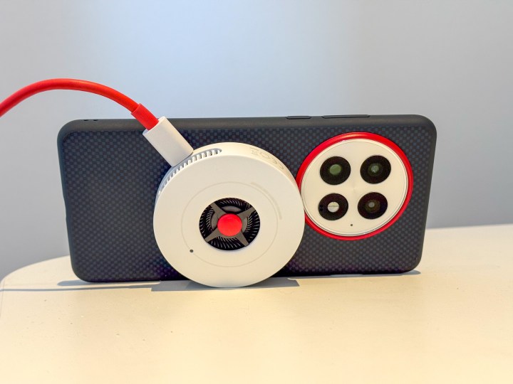 Le chargeur Airvooc OnePlus 50W attaché à un OnePlus 13 soutenu sur un bureau