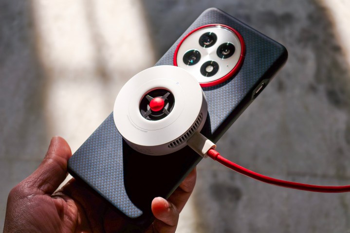 Chargeur OnePlus Airvooc 50W attaché à OnePlus 13 maintenu en main.