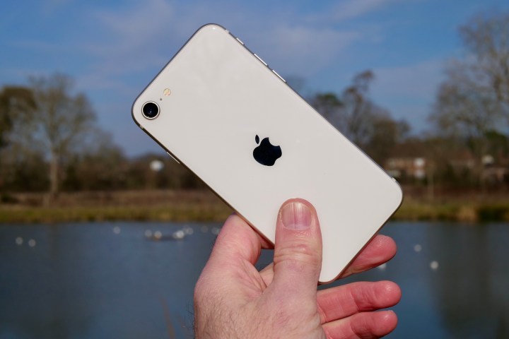 Une personne tenant l'Apple iPhone SE (2022).