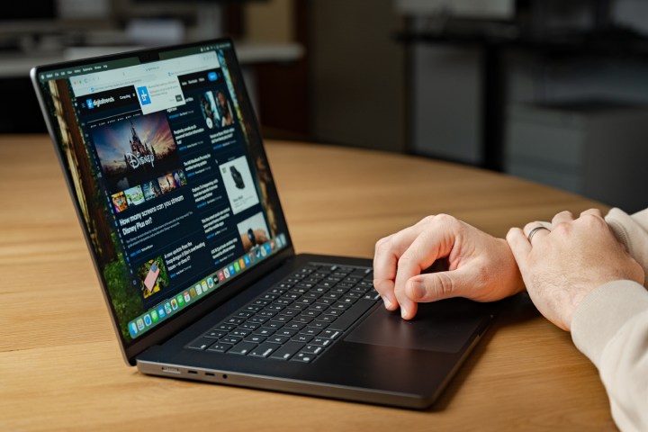 Quelqu'un utilisant un MacBook Pro à un bureau.