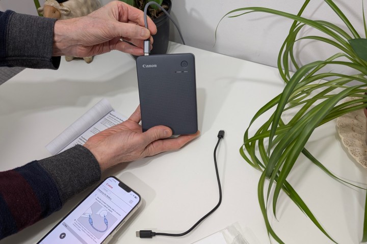 Canon regroupe un câble USB court avec le Selphy QX20, mais il fonctionne avec un câble et un chargeur USB-C standard.