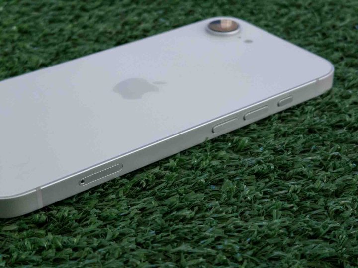 iPhone 16e sur l'herbe sous un angle