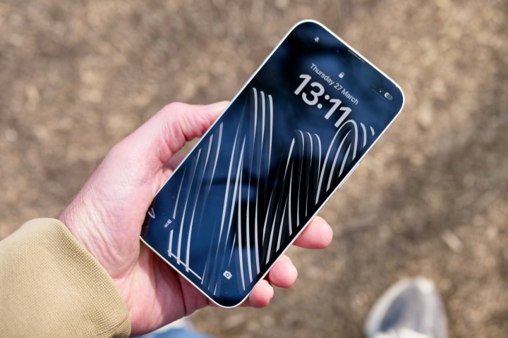 Une personne tenant l'Apple iPhone 16e montrant l'écran.