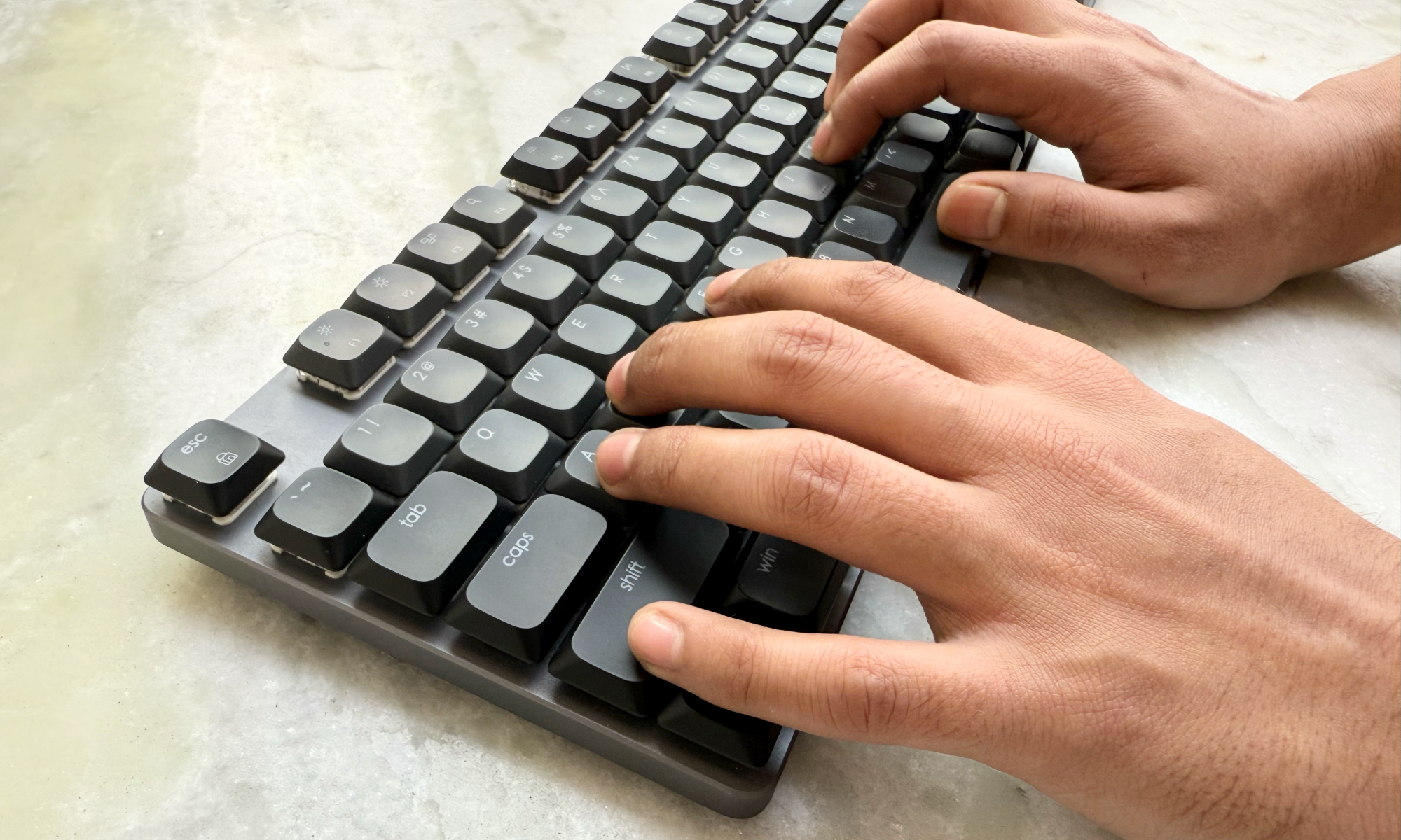 Personne tapant sur le clavier mécanique Satechi SM3 Slim.