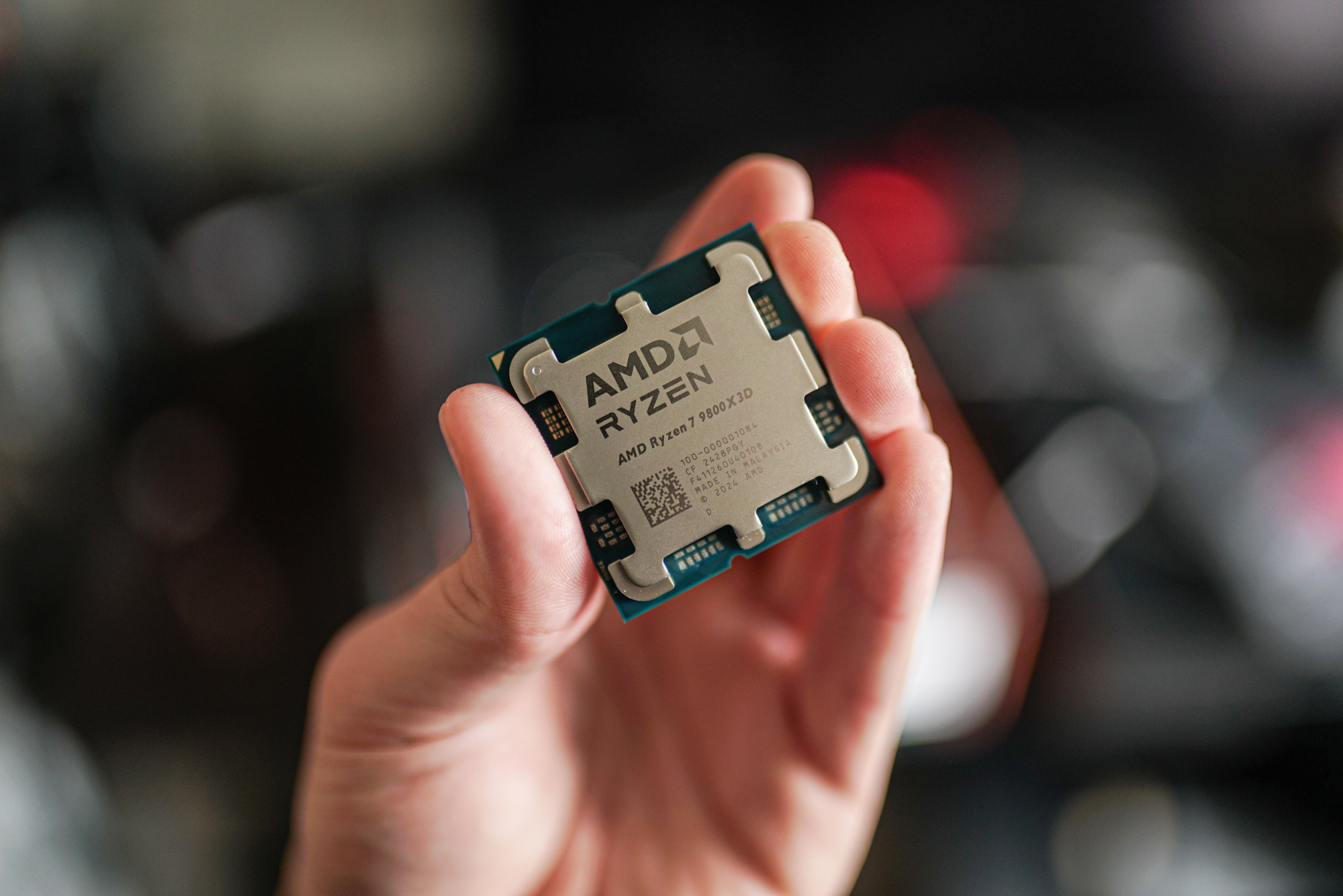 Le Ryzen 7 9800x3d tenu entre le bout des doigts.