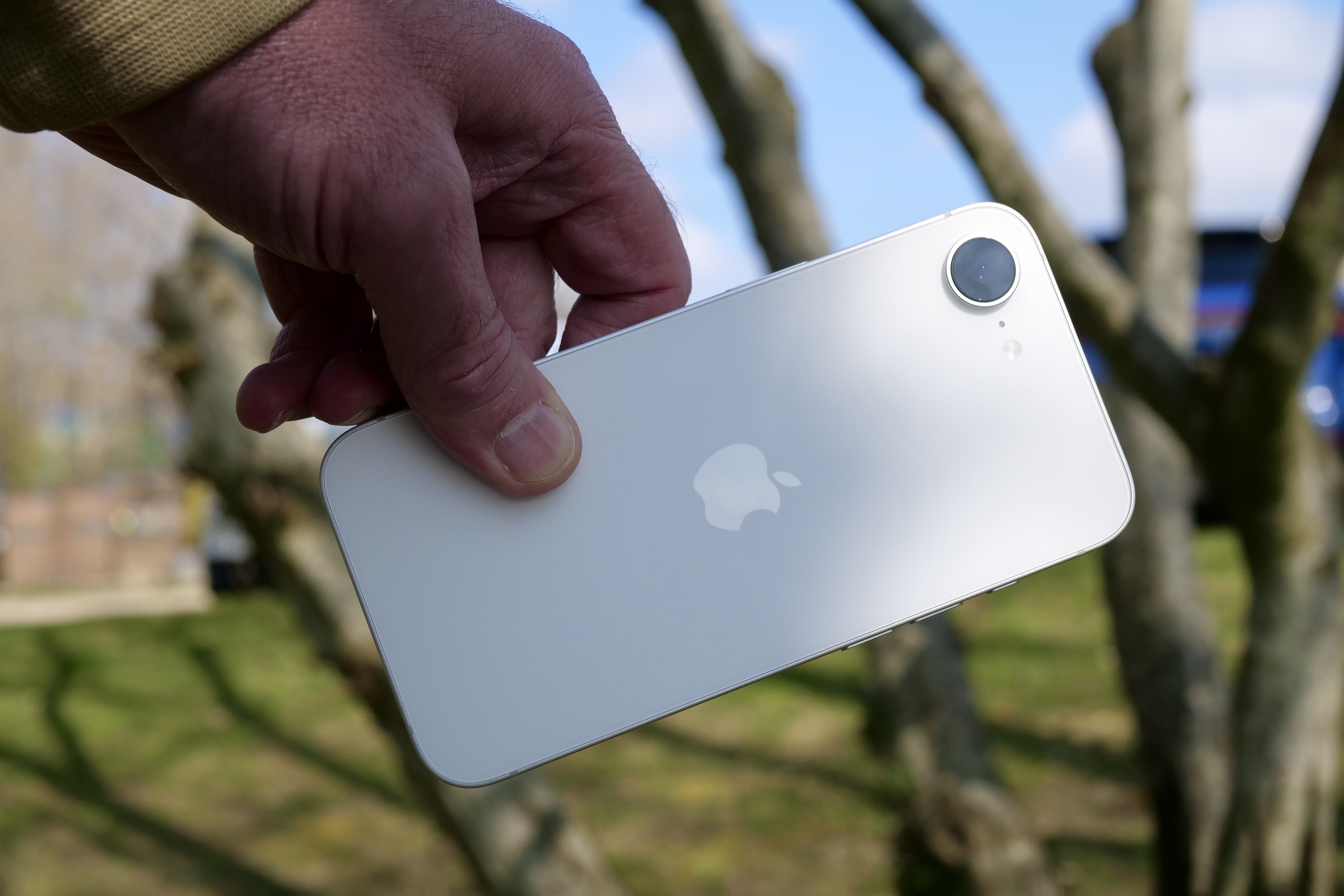 Une personne tenant l'Apple iPhone 16E.