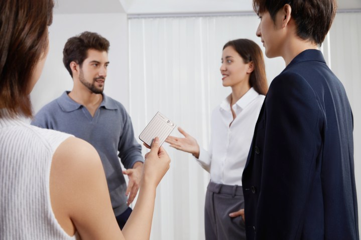Quatre collègues ont une conversation autour d'une note de note de complaudage.
