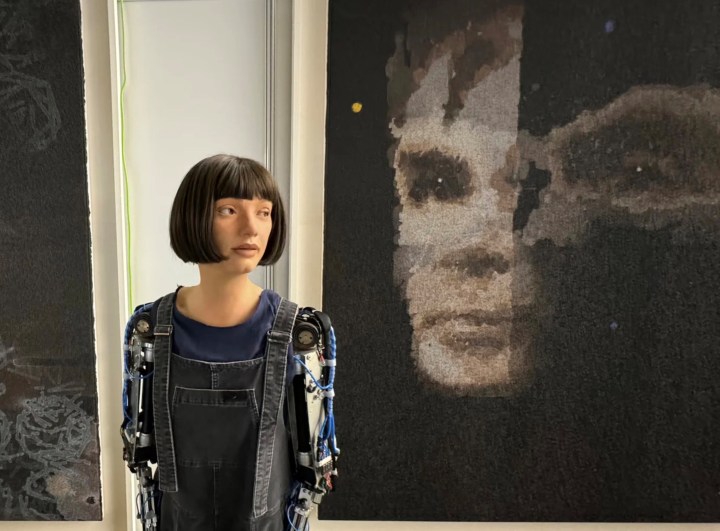 Ai-da à côté d'une autre de ses œuvres, celle du pionnier informatique Alan Turing.