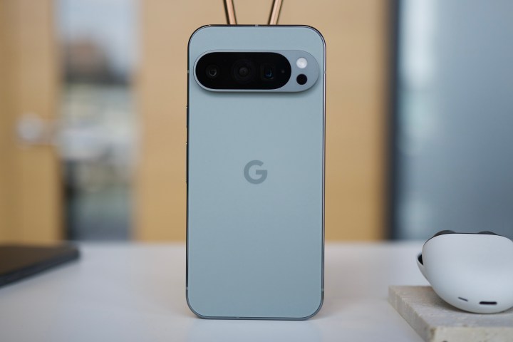 Le Google Pixel 9 Pro se tient droit sur une table.