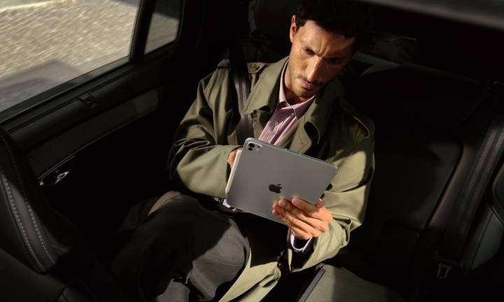 Personne sur la banquette arrière d’une voiture utilisant un iPad Pro équipé de la puce M5 d’Apple.