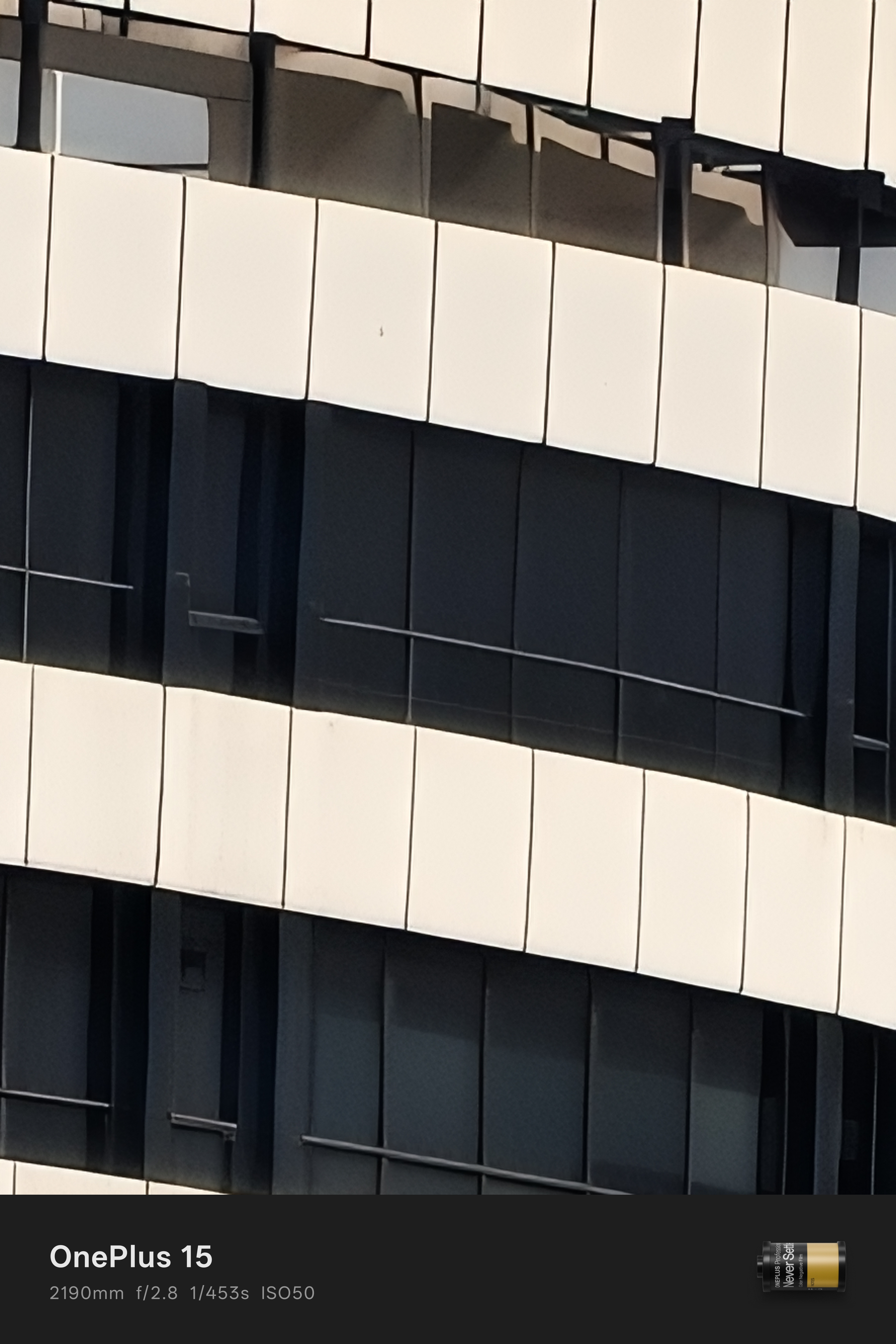 Échantillon de lumière du jour provenant de la caméra OnePlus 15 d'un bâtiment blanc avec un zoom 90x.