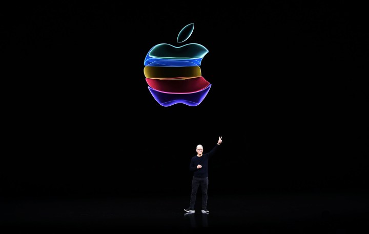 Tim Cook devant le logo Apple coloré.