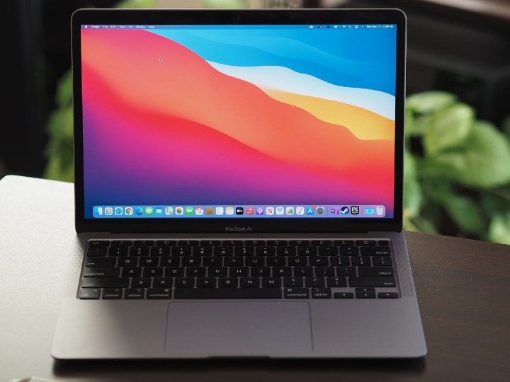 Apple M1 MacBook Air ouvert sur un bureau avec des plantes en arrière-plan.