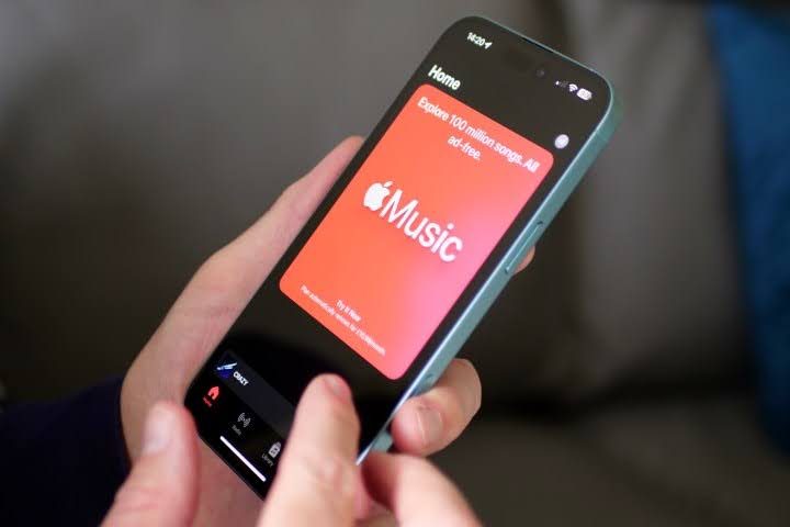 personne tenant un téléphone portable avec Apple Music à l'écran