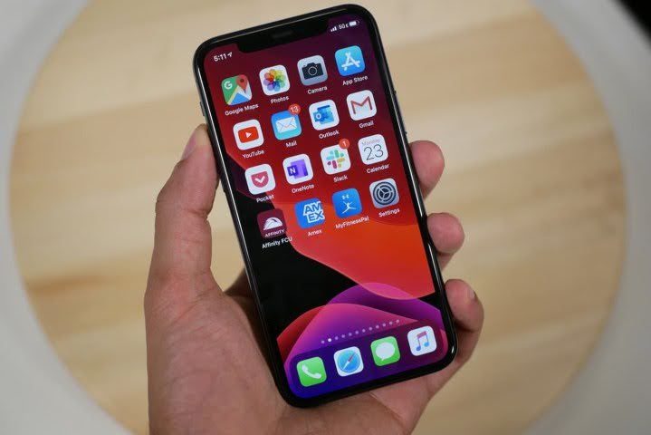 personne tenant un téléphone portable avec des icônes Apple iOS
