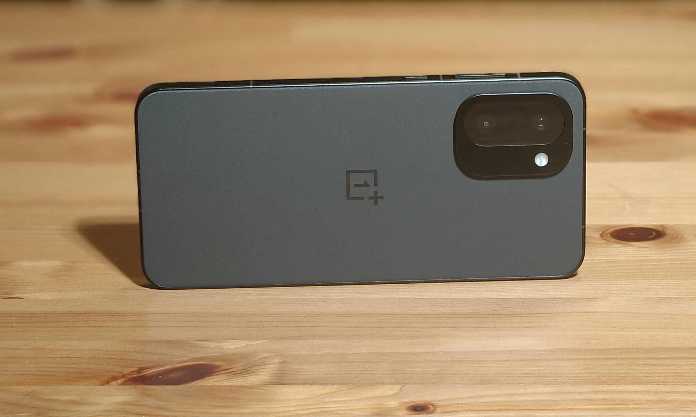 L'arrière du OnePlus 15R, horizontal sur une table en bois.