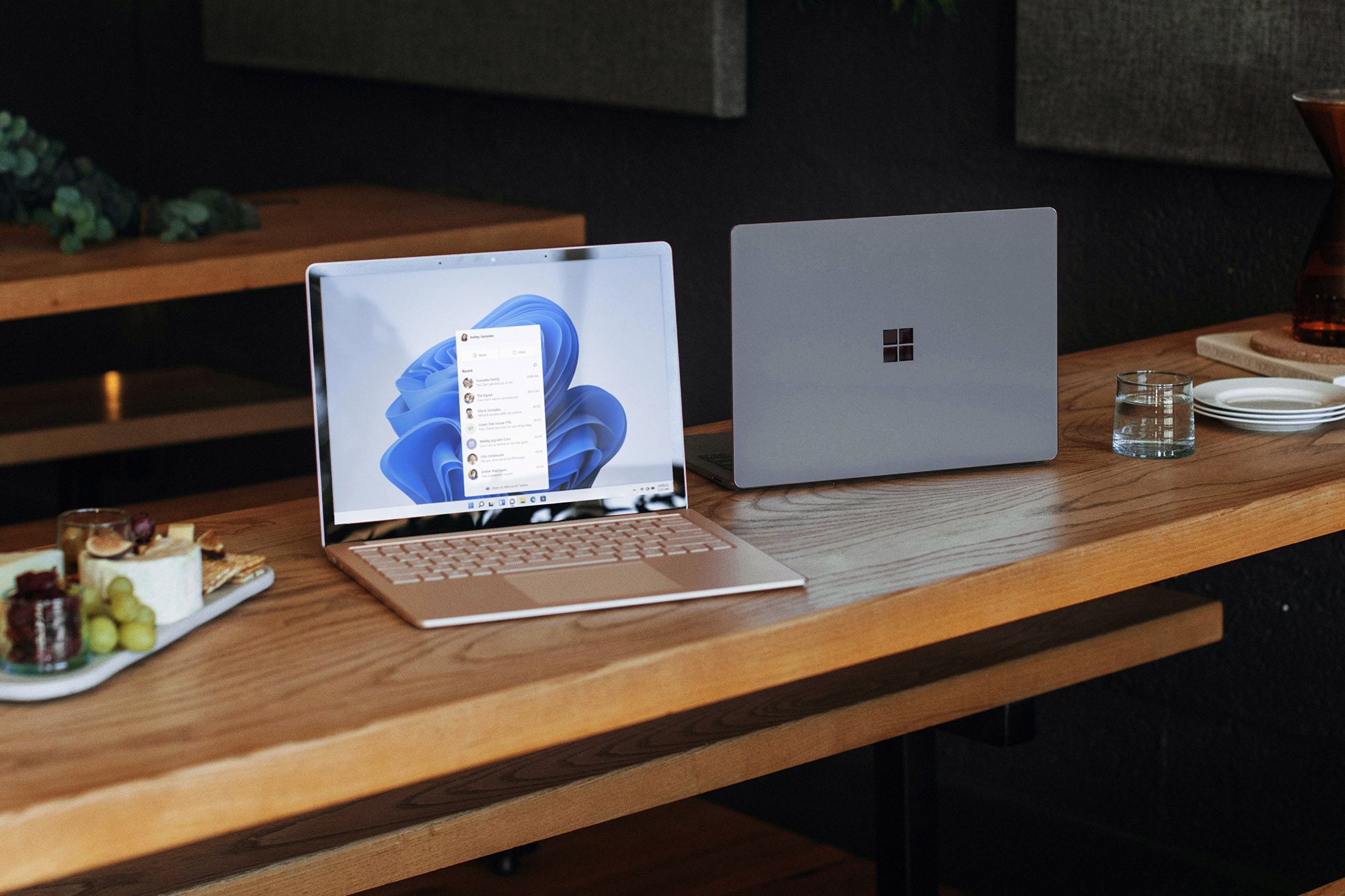Deux ordinateurs portables Windows sont posés sur une table en bois.