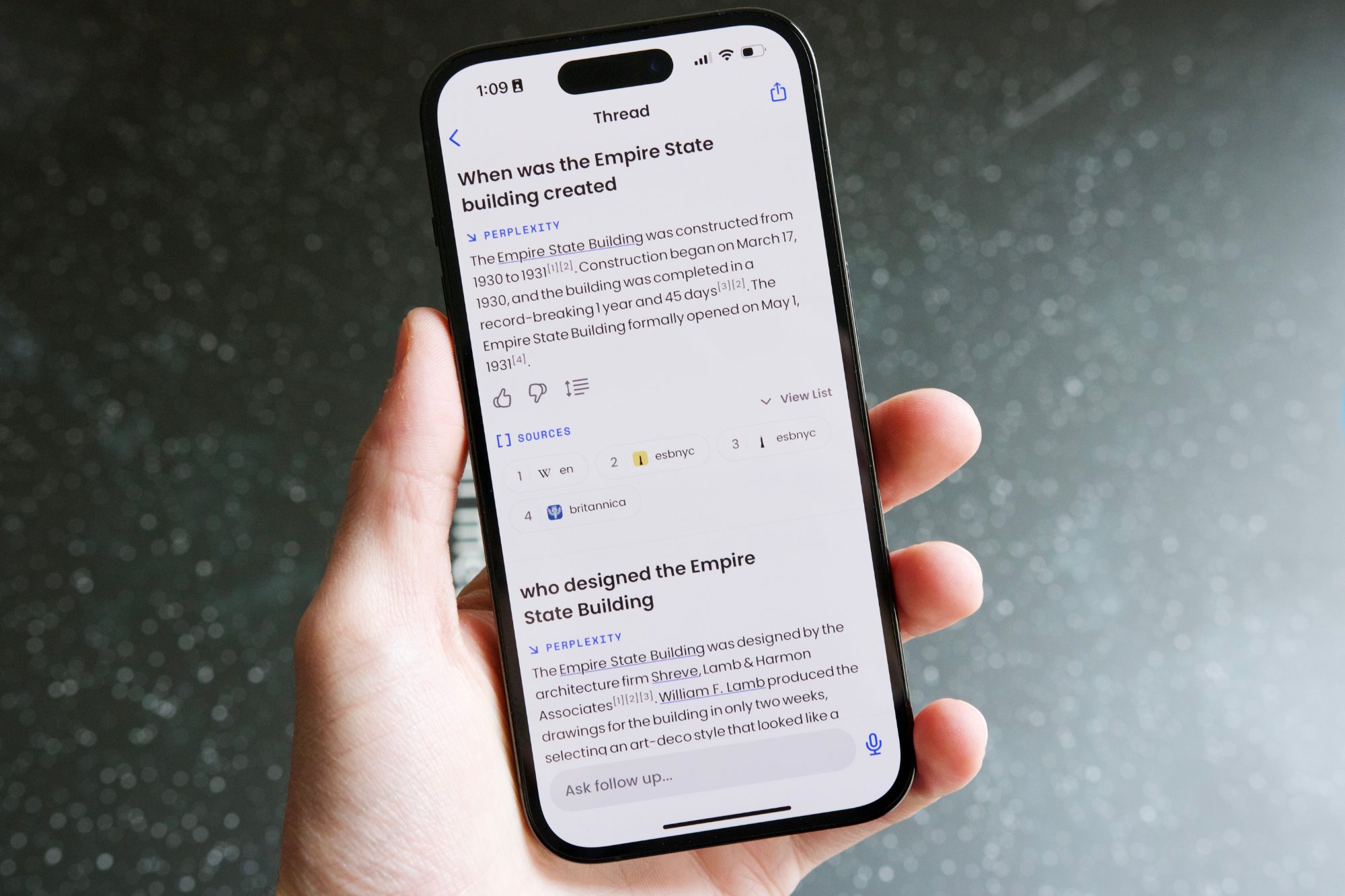 Quelqu’un tenant un iPhone 14 Pro, sur lequel fonctionne Perplexity AI.