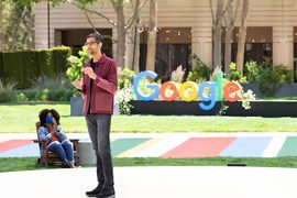 Sundar Pichai se tient devant un logo Google lors de Google I/O 2021.
