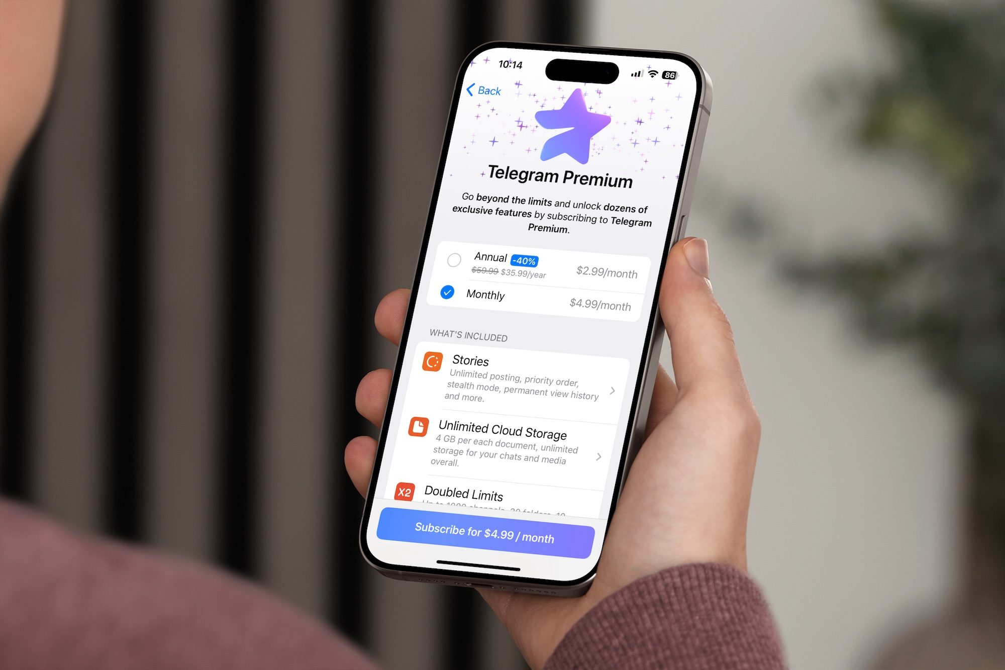 Personne détenant un iPhone avec la page de commande Telegram Premium affichée.