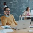 Man talking on phone in modern office with team