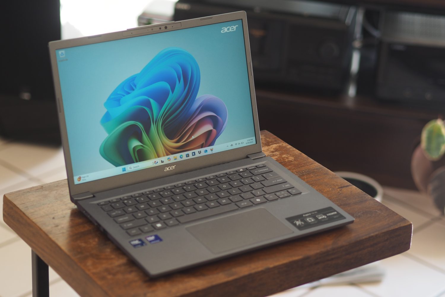 Vue inclinée avant de l'Acer Aspire 14 AI montrant l'écran et le pavé tactile.