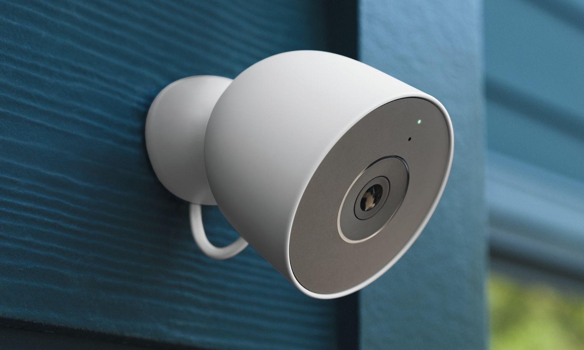 Google Nest Cam Outdoor filaire installée sur un mur bleu
