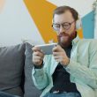 Man with headphones playing game on smartphone