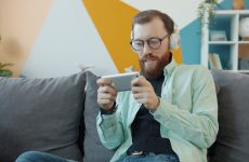 Man with headphones playing game on smartphone