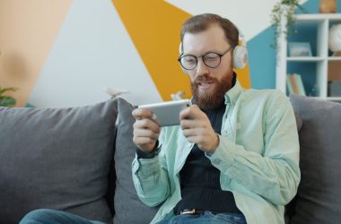 Man with headphones playing game on smartphone