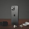 A smartphone, a smartwatch, and wireless earbuds on a wooden surface