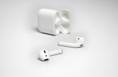 AirPods posés devant leur boîtier de charge ouvert