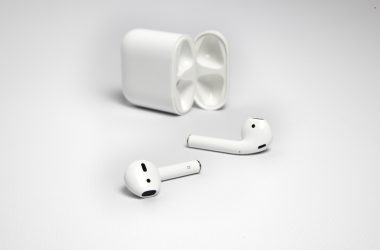 AirPods posés devant leur boîtier de charge ouvert