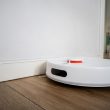 Aspirateur robot laveur nettoyant un parquet dans un salon