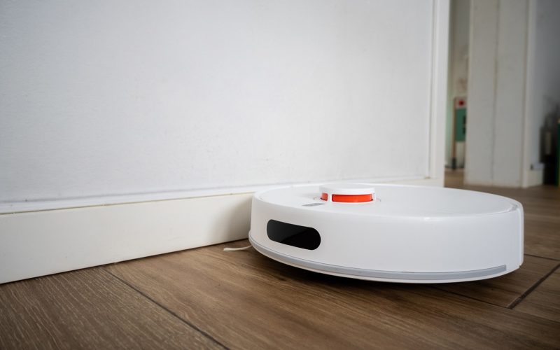 Aspirateur robot laveur nettoyant un parquet dans un salon