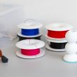 Bobines de filament pour imprimante 3D de différentes couleurs posées sur un bureau