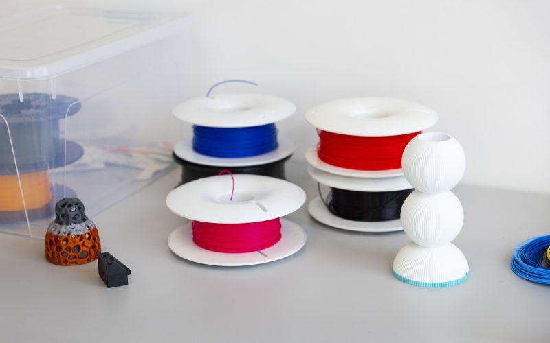 Bobines de filament pour imprimante 3D de différentes couleurs posées sur un bureau