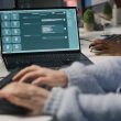 Ordinateur portable affichant la fenêtre de conversation d'un chatbot IA, devant une personne qui tape au clavier