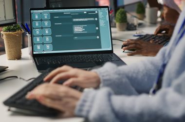 Ordinateur portable affichant la fenêtre de conversation d'un chatbot IA, devant une personne qui tape au clavier